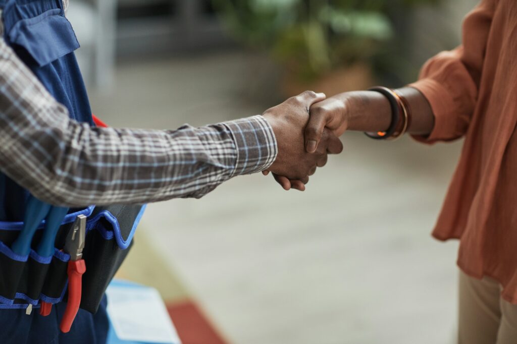 Woman Shaking Hands with Handyman